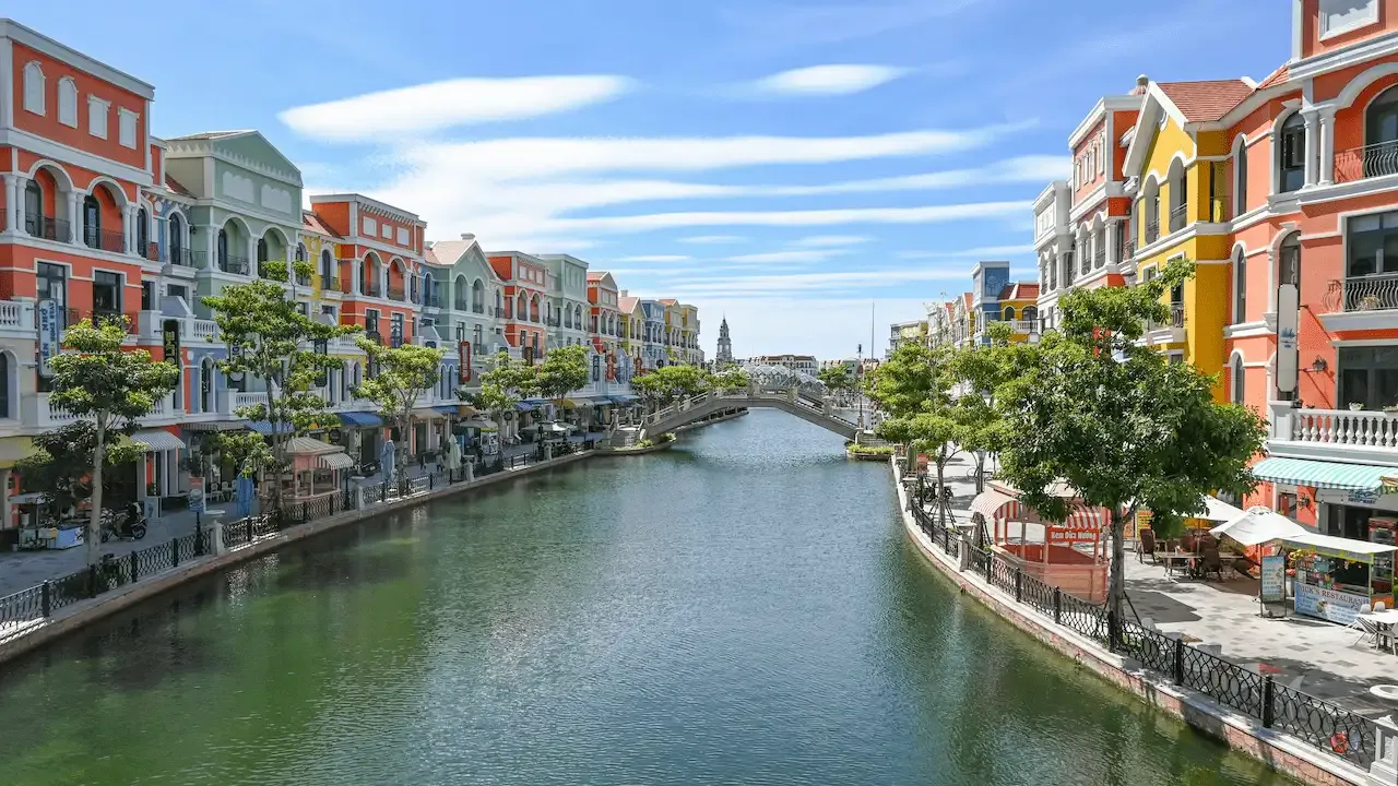 Colorful buildings line a canal with a bridge.