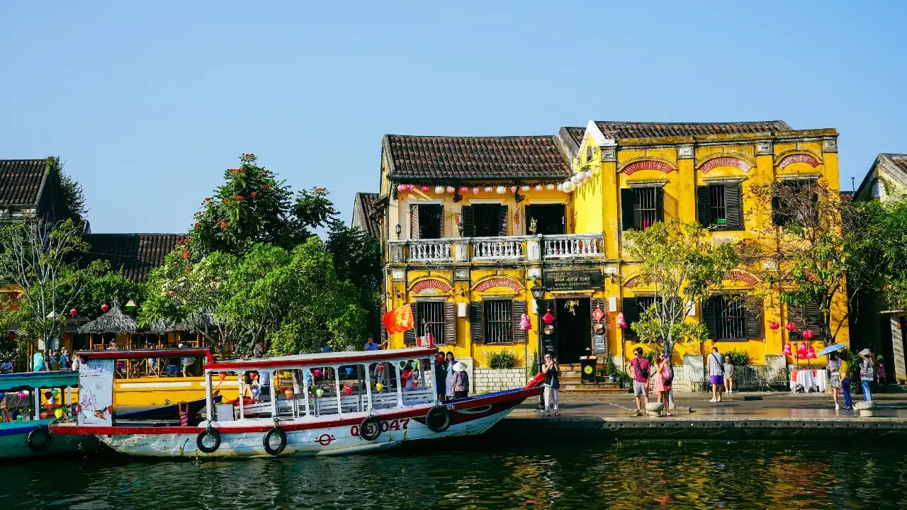 boat in the canal in Hoi An whit yellow row houses behind it