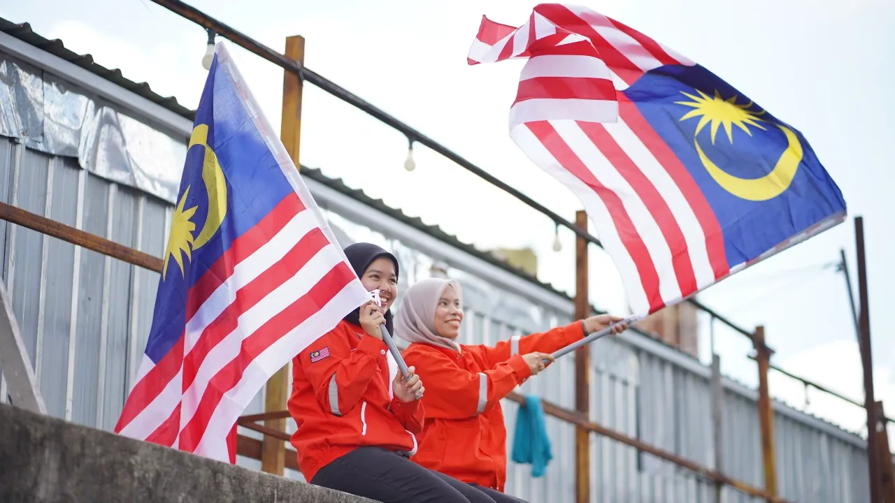 female malaysian safety officers waving the flag